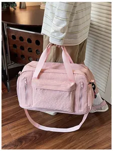 Close-up of a large pink travel duffel bag featuring multiple pockets and durable straps.