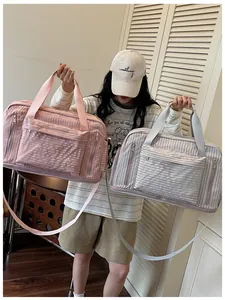 Large capacity travel duffel bags in pink and grey colors shown with a female model