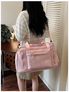 Large pink travel bag with multiple pockets shown on model for size perspective