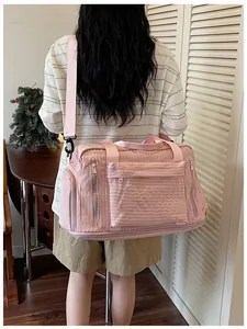 Large capacity pink travel duffle bag carried by model, showing side and rear view detail