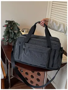 Detailed view of dark grey checkered duffel bag with multi-pocket storage design
