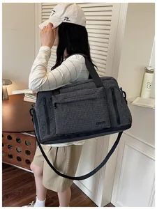 Large capacity checkered travel bag worn by a model in a casual lifestyle setting
