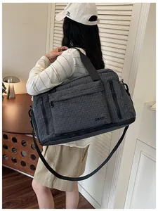 Stylish person carrying a large capacity gray checkered travel bag in a modern room