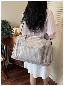 Woman carrying a striped large capacity travel duffel bag in a lifestyle setting