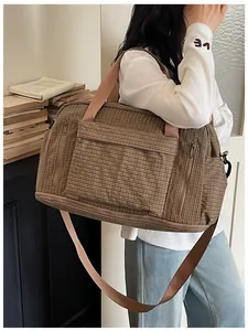 Large brown plaid travel bag with adjustable strap shown in a lifestyle indoor setting