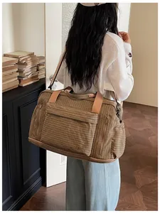 Fashionable striped large capacity travel bag carried by a model in a cozy indoor setting