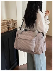 Detailed side view of a lavender expandable travel duffle bag carried by a model