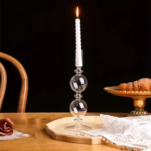 Elegante candelabro de vidrio transparente con diseño esférico y vela encendida