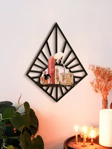 Modern black diamond-shaped wall shelf displaying crystals and aroma diffuser in a home