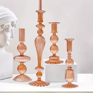 Vista dettagliata di eleganti candelabri in vetro ambrato a righe in varie forme artistiche