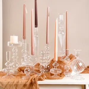 Diverse collection of clear glass candlesticks with striped and orb designs for decor