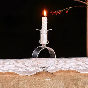 Primer plano de una vela en espiral blanca encendida en un candelabro de cristal