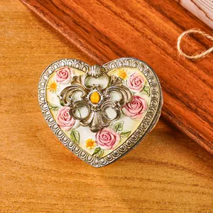 Detailansicht einer herzförmigen Vintage-Schmuckschatulle mit kunstvollen Rosen-Schnitzereien