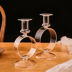 Elegantes candelabros de vidrio transparente con diseño circular en una mesa de madera