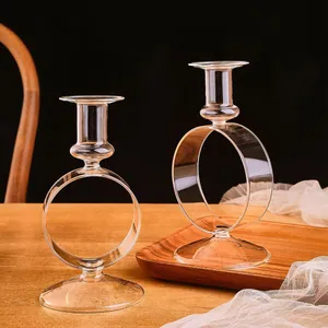 Portavelas elegantes de vidrio transparente con un diseño circular sobre bandeja madera