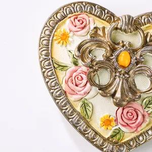 Makro-Detail einer antiken europäischen Herz-Schmuckschatulle mit 3D-Blumen-Harzschnitzerei.