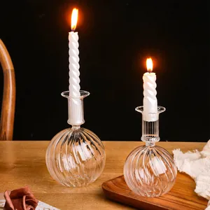 Detailweergave van glazen kandelaars met brandende spiraalkaarsen op een houten tafel