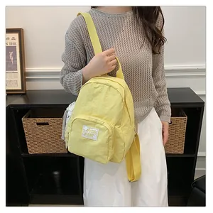 Detailed view of a model wearing a minimalist yellow casual backpack in a stylish room