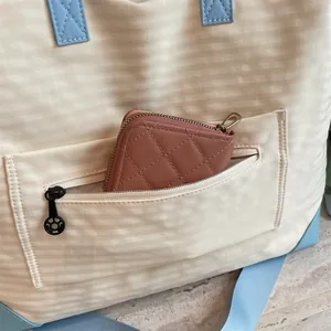 Dettaglio della tasca con cerniera di una borsa da viaggio leggera con mini portafoglio
