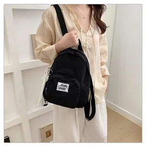 Detailed shot of a minimalist black backpack with lace patch on a model