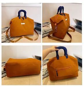 Viste dettagliate di una grande borsa da viaggio arancione con manici blu