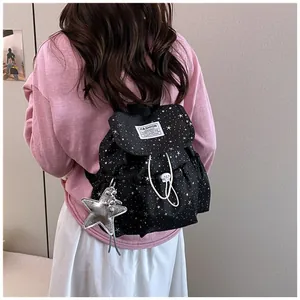 Rear view of a stylish black star-print backpack worn by a female student