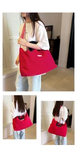 Modella che porta una grande borsa da viaggio rossa che mostra il suo design spazioso