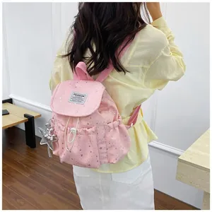 Close-up of stylish pink star-patterned backpack with silver balloon dog charm pendant
