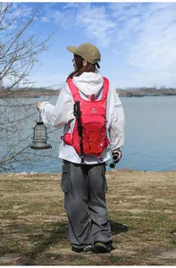Donna fa trekking al lago con uno zaino outdoor rosa leggero e una lanterna