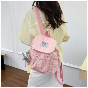 Small pink star pattern backpack for women shown on a model's back in a soft setting