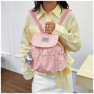 Detail of pink Japanese style mini backpack with shiny star patterns and star charm