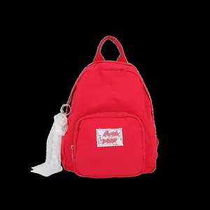 Casual red nylon backpack for students featuring a front lace-edged brand patch