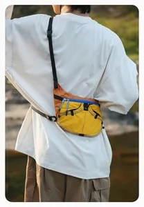 Lifestyle-Aufnahme einer farblich abgesetzten gelben und orangen Tasche im Freien