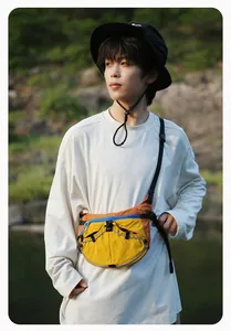 Outdoor-Lifestyle-Detailaufnahme einer lebendigen Colorblock-Crossbody-Bag an einem Model