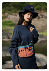 Detaillierte Ansicht einer trendigen Outdoor-Umhängetasche an einem asiatischen Model.