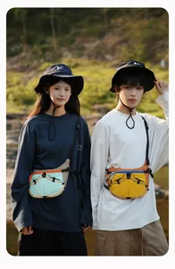 Asiatische Modelle tragen stilvolle Sport-Freizeit-Taschen in Farbmischung im Freien