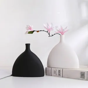 Detailweergave van minimalistische zwart-witte semi-ovale harsvazen voor decoratie.