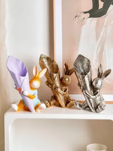Detail view of three resin bunny flower vases in colorful, gold, and silver finishes