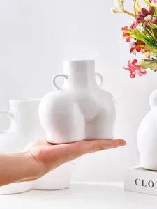 Vista detallada del jarrón minimalista blanco con forma de glúteo para comparar tamaño.
