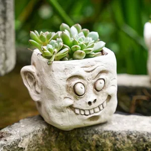 Vue détaillée d'un pot de fleurs créatif en résine avec une tête de démon amusante.