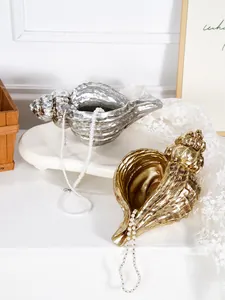 Macro view of gold and silver conch-shaped resin vases for elegant home decoration