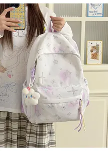 Detail eines weißen Schülerrucksacks mit lila Sternenmuster und Plüschanhänger.