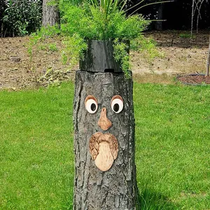 Vista detallada de decoración creativa de cara de árbol en un tronco de jardín