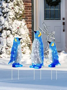 Drei blaue Pinguin-Gartenstecker in einer verschneiten Außenumgebung in Nahaufnahme