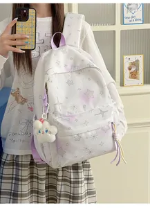 Detailansicht des weißer Rucksacks mit Sternmuster, lila Akzenten und Plüsch-Anhänger.