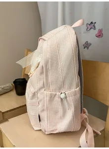 Detailed side view of a pink checkered school backpack featuring a functional side pocket