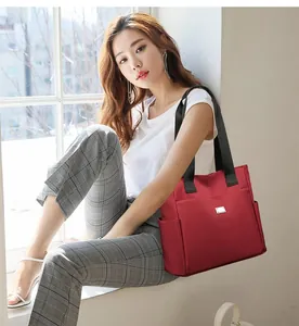 Detailansicht einer großen roten Oxford-Stofftasche, getragen von einem asiatischen Model