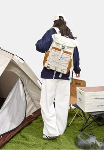 Detail view of outdoor backpack with bungee cord design in a realistic camping setting