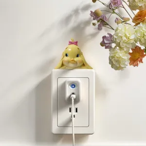 Close-up detail of a cute yellow duck resin ornament on a white wall power switch