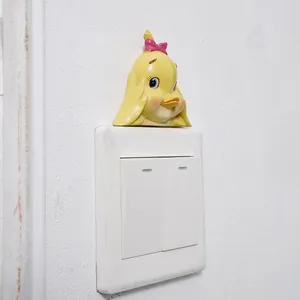 Creative and cute yellow duck resin wall decoration sticker placed on a white indoor light switch